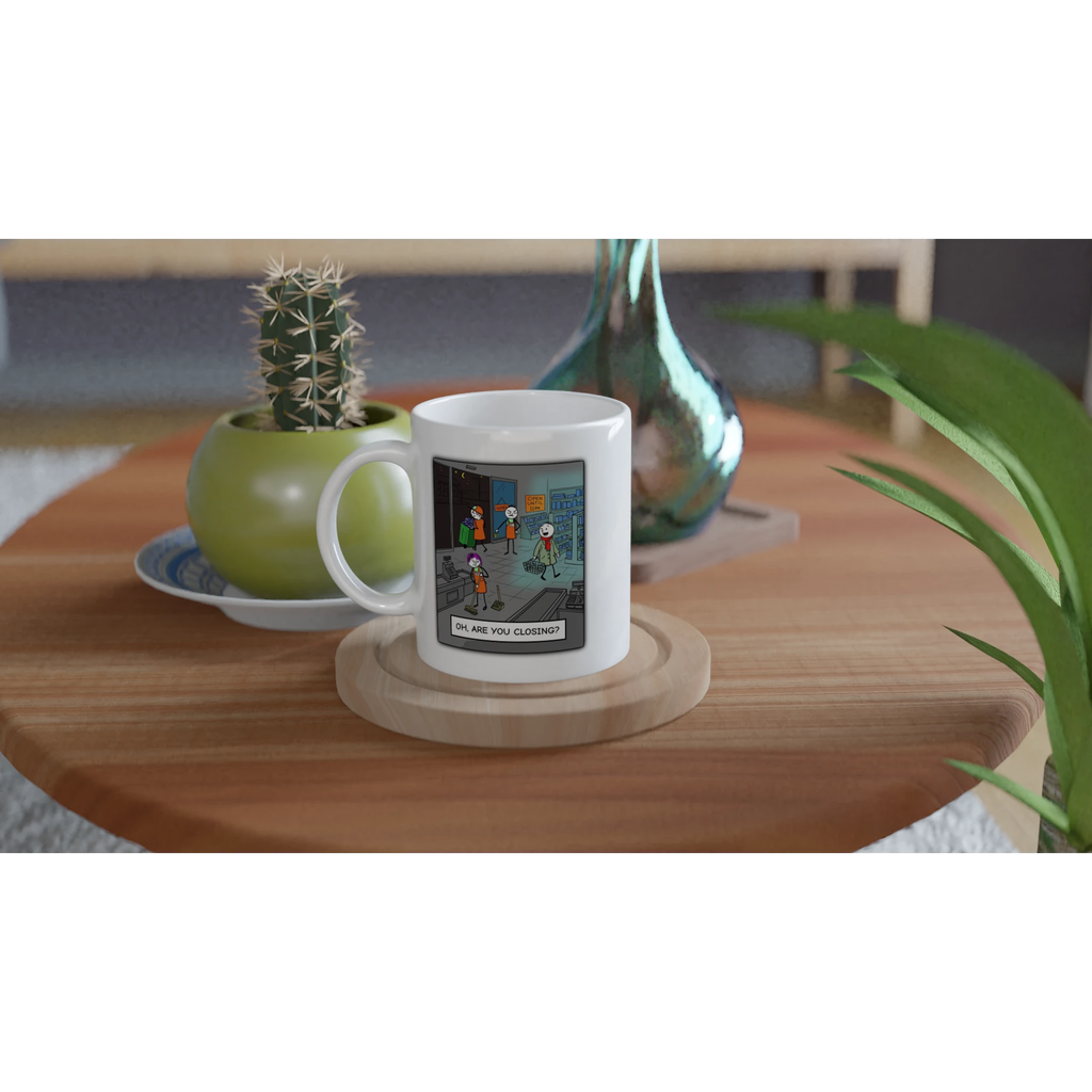 Lifestyle image of a mug featuring annoyed retail staff cleaning up at closing time while an oblivious customer asks, 'Oh, are you closing?' – humorous retail worker cartoon by Retailer Therapy