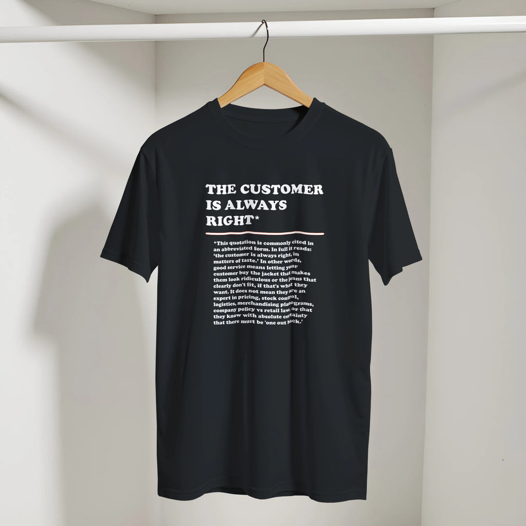 Front view of a black T-Shirt on a hanger featuring the phrase "The Customer is Always Right*" with a humorous disclaimer explaining why the customer is not always right by Retailer Therapy.