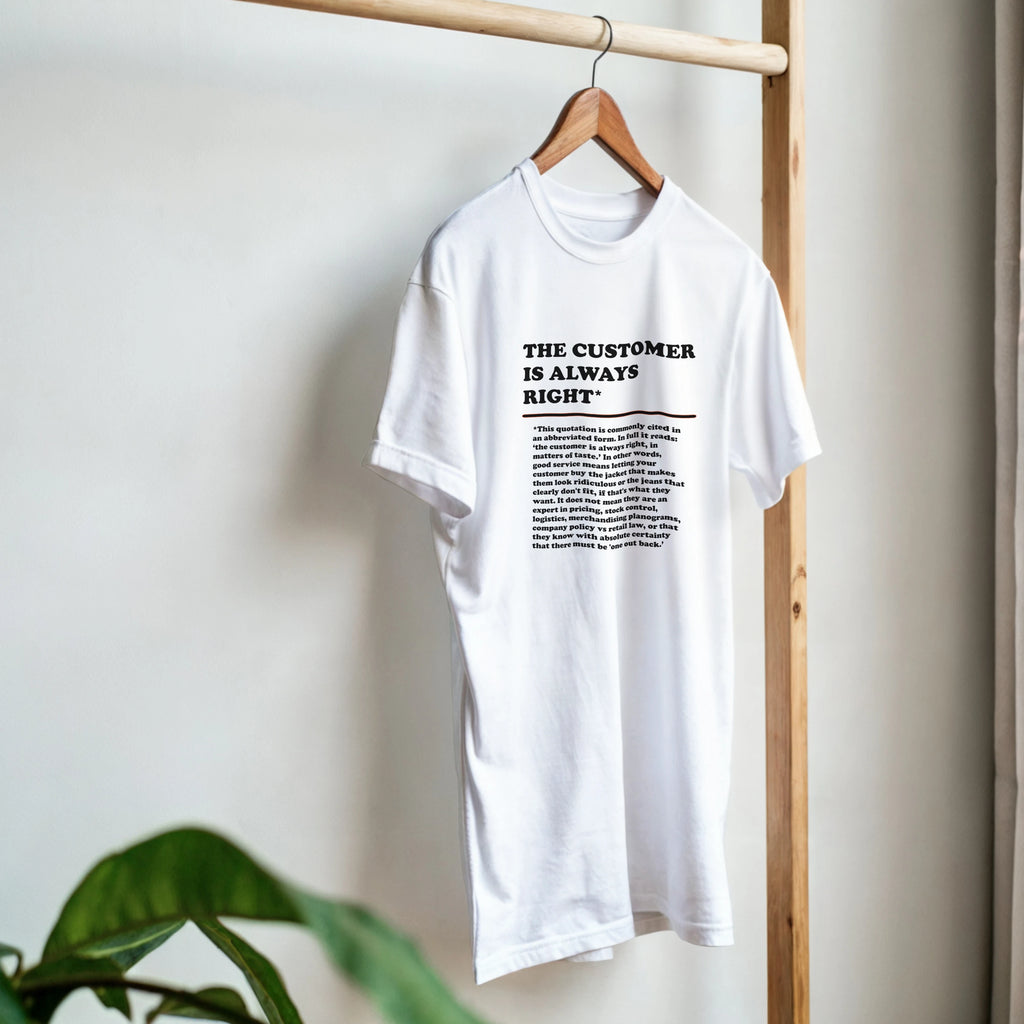 Front view of a white T-Shirt on a hanger featuring the phrase "The Customer is Always Right*" with a humorous disclaimer explaining why the customer is not always right by Retailer Therapy.