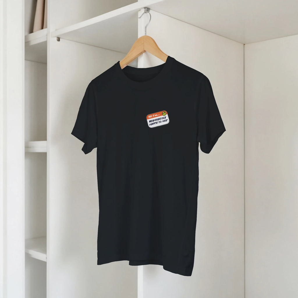 Front view of a black t-shirt on a hanger with a printed imitation nametag saying 'Hi! I'm Moderately Here to Help' by Retailer Therapy