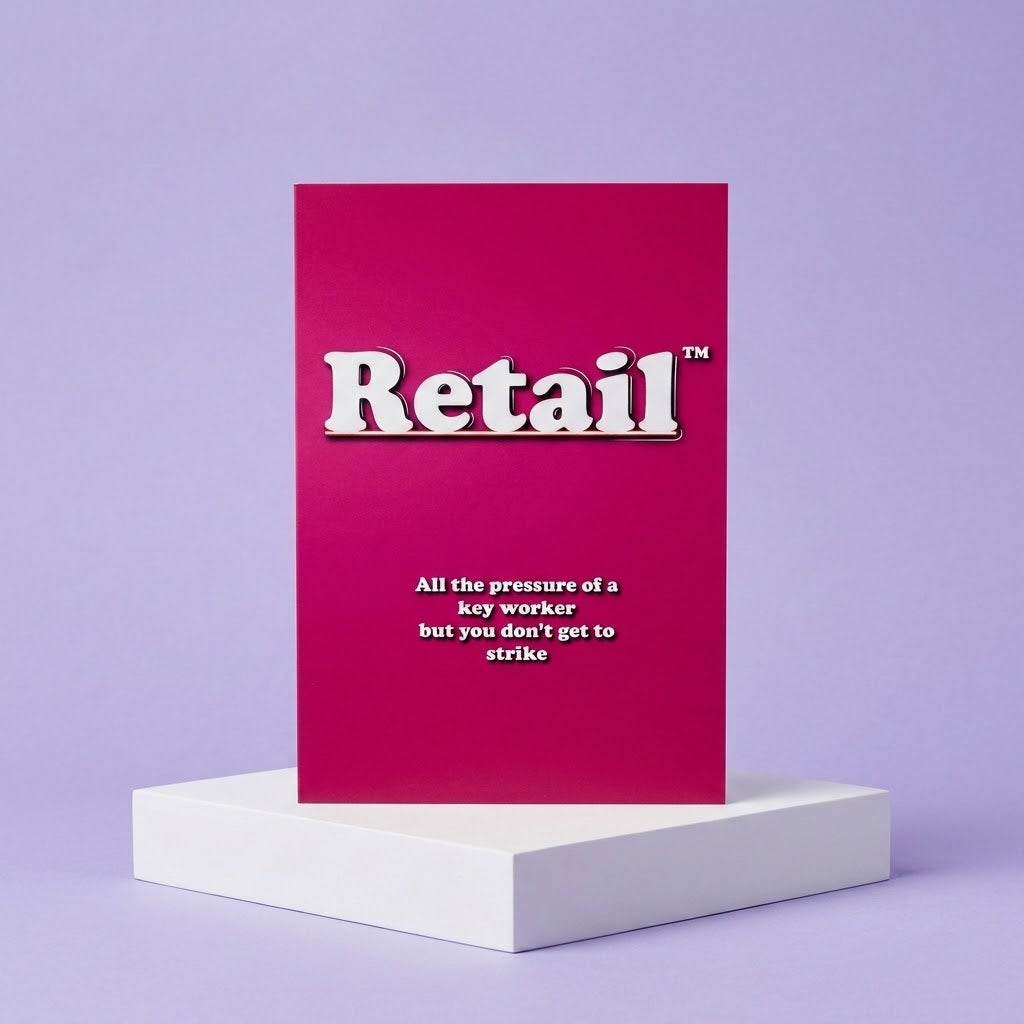 A magenta greeting card with the word 'Retail' in large white letters and a subtitle about worker pressure, displayed upright on a white pedestal against a lavender background.
