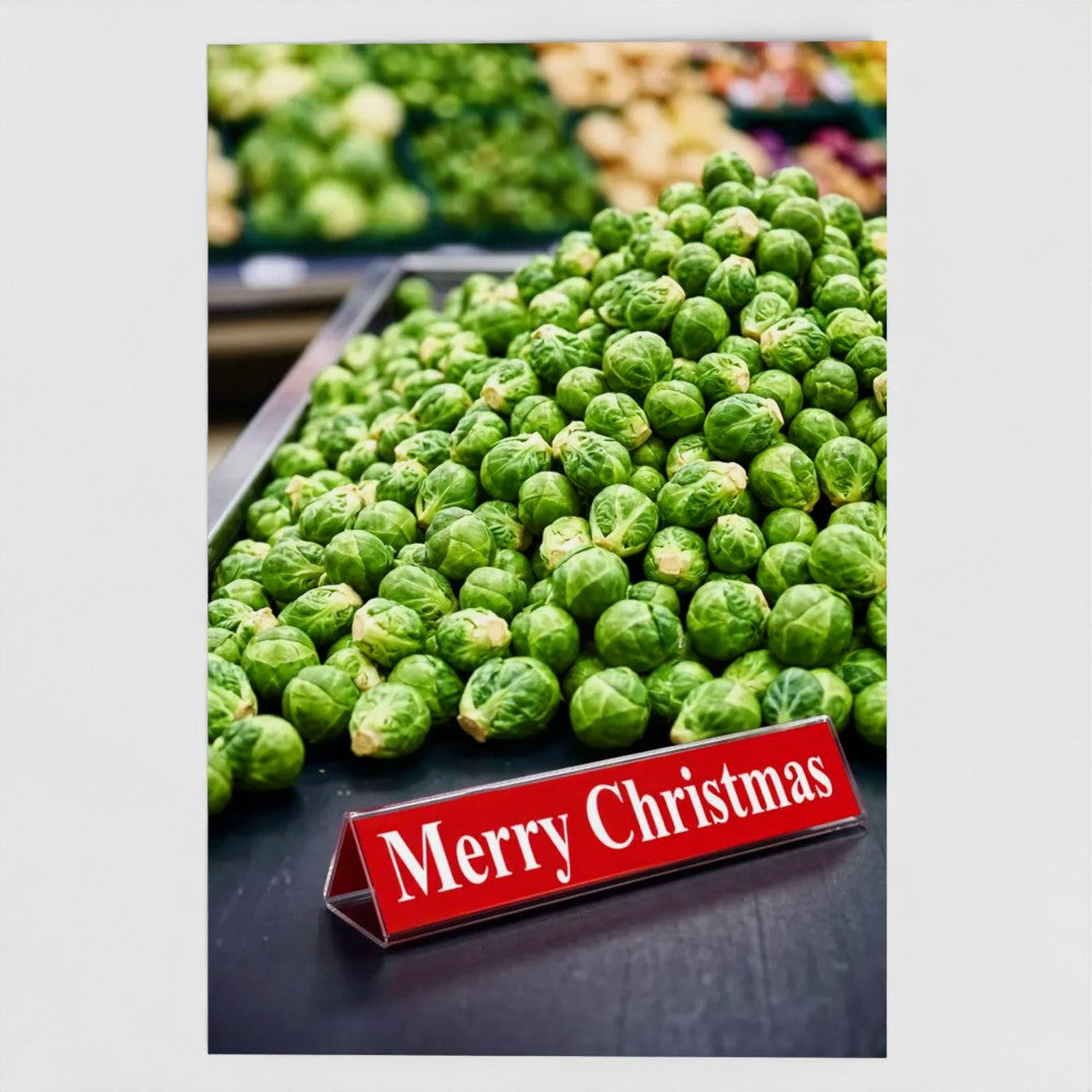 A vertical rectangular print or card featuring a close-up photo of a pile of green Brussels sprouts in a produce display, with a red tabletop sign reading “Merry Christmas.” The print is centered on a light gray background.